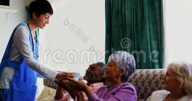 高加索女医生在<strong>养老院</strong>为老年人提供咖啡的侧视4k